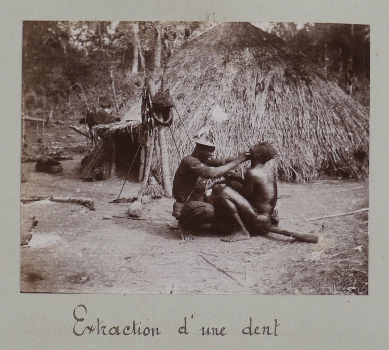 Item #607 [Album with 106 Original Gelatin Silver Photographs, Documenting an Early Travel up the Congo and Ubangi Rivers to Fort Crampel in French Congo (now Kaga-Bandoro, Central African Republic) and Showing Boma, Matadi, Bangui, Ibenga Village, Ubangi, Nana and Chari Rivers, Fort Crampel, French Fortifications, a Hotchkiss Gun, Bush Camps during the Suppression of Local Tribes, Village Scenes, Portraits of Bondjo (Ekonda), M’Bres, M’Gaos and Ouham People, Members of Native Militia, a Doctor Pulling a Teeth, a Local Chief, &c.]. AFRICA – CENTRAL AFRICAN REPUBLIC.